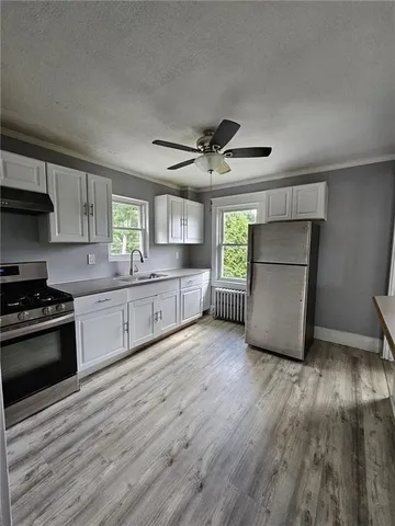 a kitchen with stainless steel appliances granite countertop a stove a sink and a refrigerator