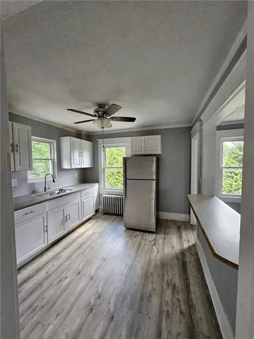 a kitchen with stainless steel appliances granite countertop a sink window and cabinets