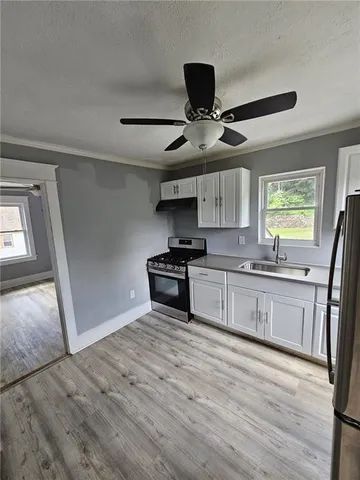 a kitchen with stainless steel appliances granite countertop a sink and wooden floor