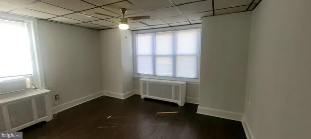 a room with wooden floor and windows