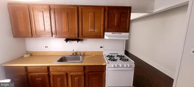 a kitchen with a sink a stove and cabinets