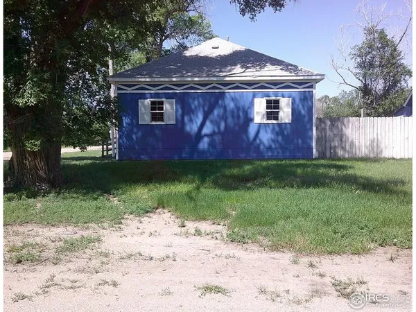 a backyard of a house with table and chairs