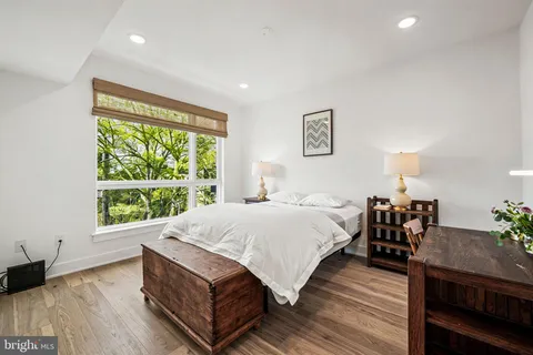 a spacious bedroom with a bed and wooden floor