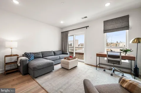 a living room with furniture a rug and a window