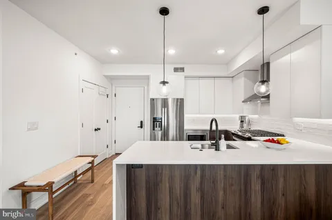 a kitchen with kitchen island a sink stainless steel appliances and cabinets