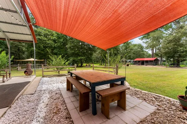 a view of a street with potted plants and large trees