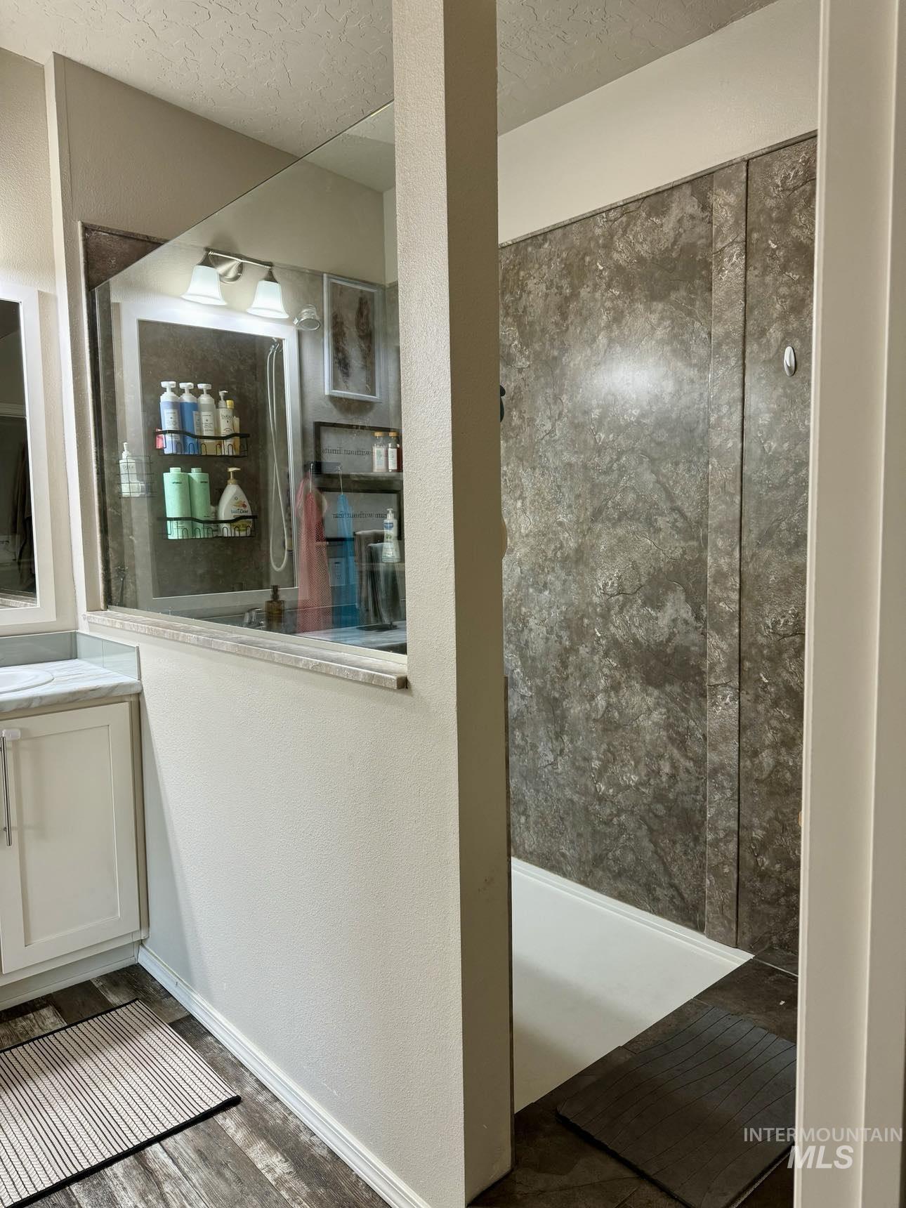 986 Parade Avenue Lapwai, ID 83540 - Photo 11 of 12 Full bath featuring vanity, wood finished floors, walk in shower, a textured ceiling, and a textured wall