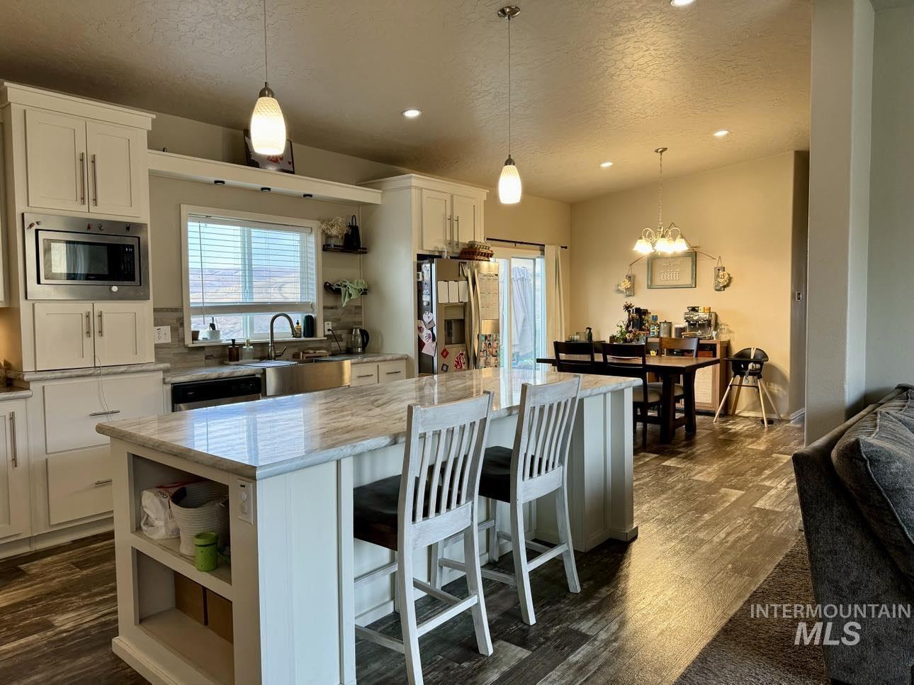 986 Parade Avenue Lapwai, ID 83540 - Photo 4 of 12 Kitchen featuring open shelves, a textured ceiling, a kitchen island, appliances with stainless steel finishes, and white cabinetry