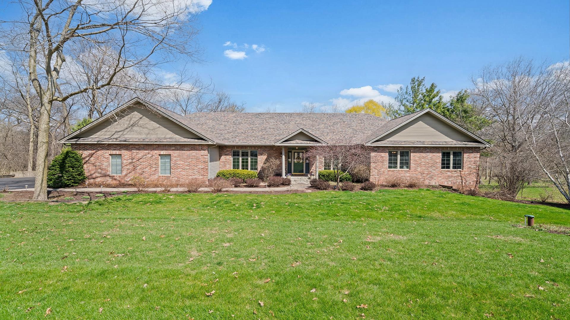 7676 Forest Way Roscoe, IL 61073 - Photo 2 of 56 a front view of a house with a garden and yard