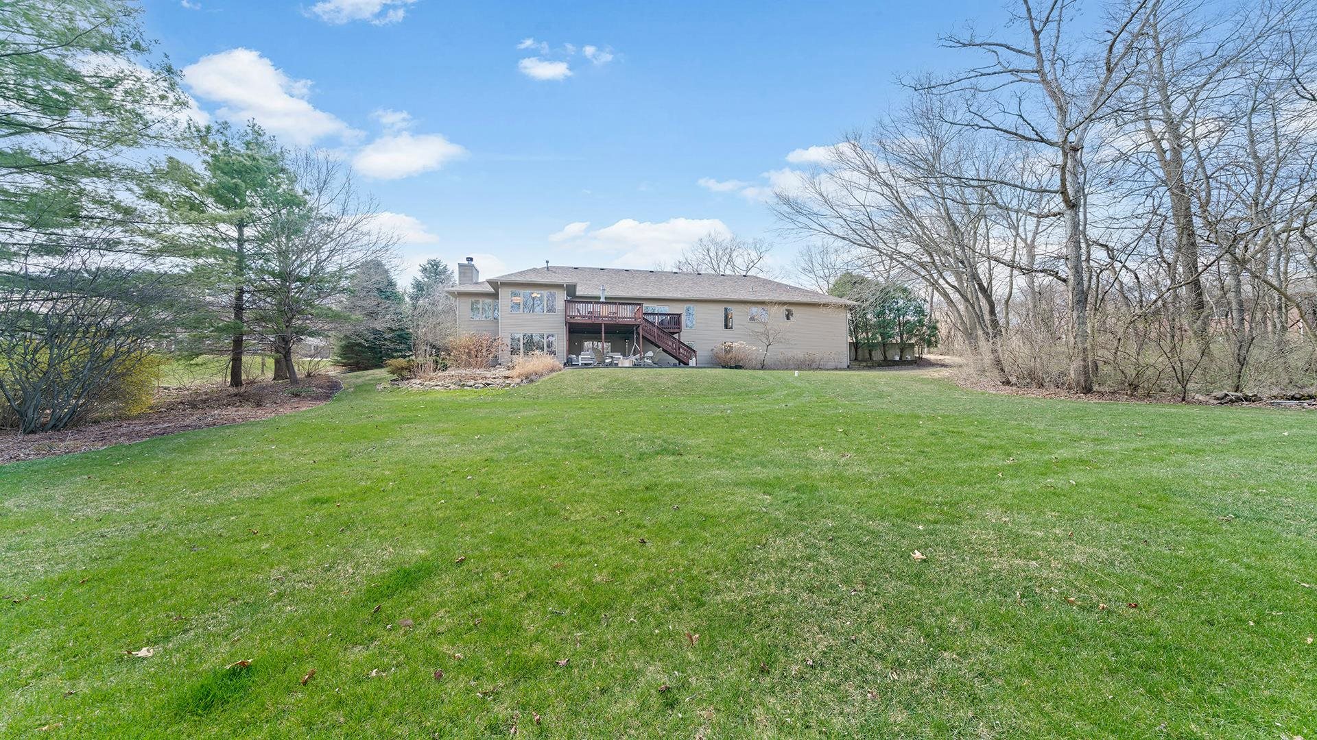 7676 Forest Way Roscoe, IL 61073 - Photo 54 of 56 a view of a house with a big yard and a large tree