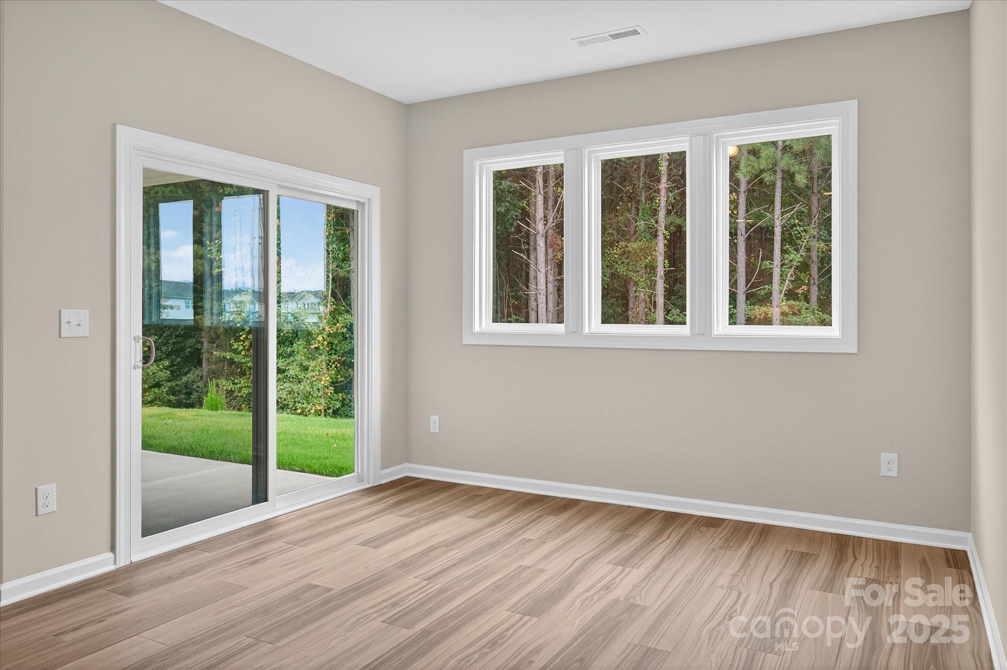 7926 Rolling Wheels Road, Unit KEN0008 Charlotte, NC 28215 - Photo 14 of 47 a view of an empty room with wooden floor and a window
