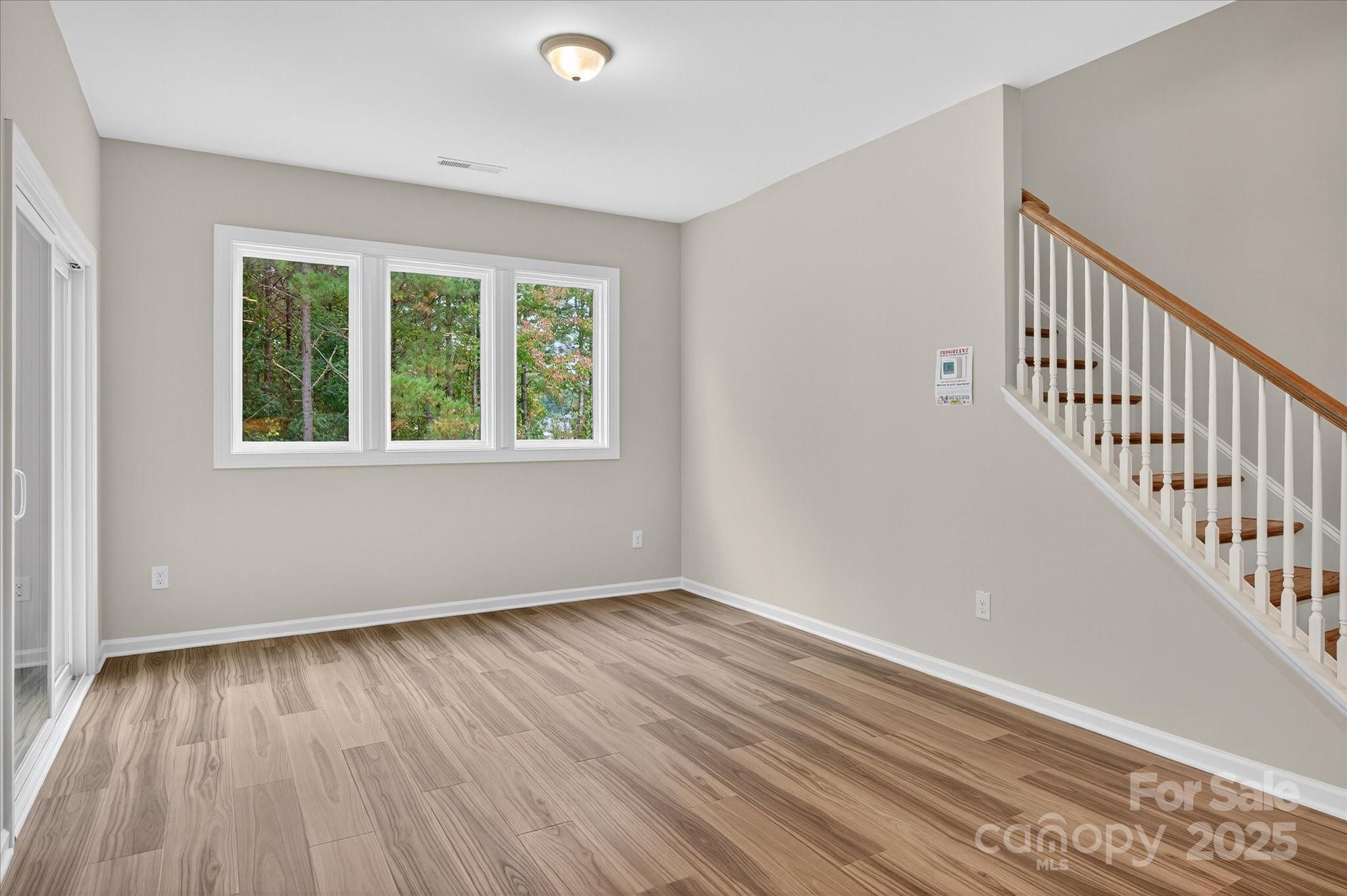 7926 Rolling Wheels Road, Unit KEN0008 Charlotte, NC 28215 - Photo 15 of 47 a view of an empty room with wooden floor and a window