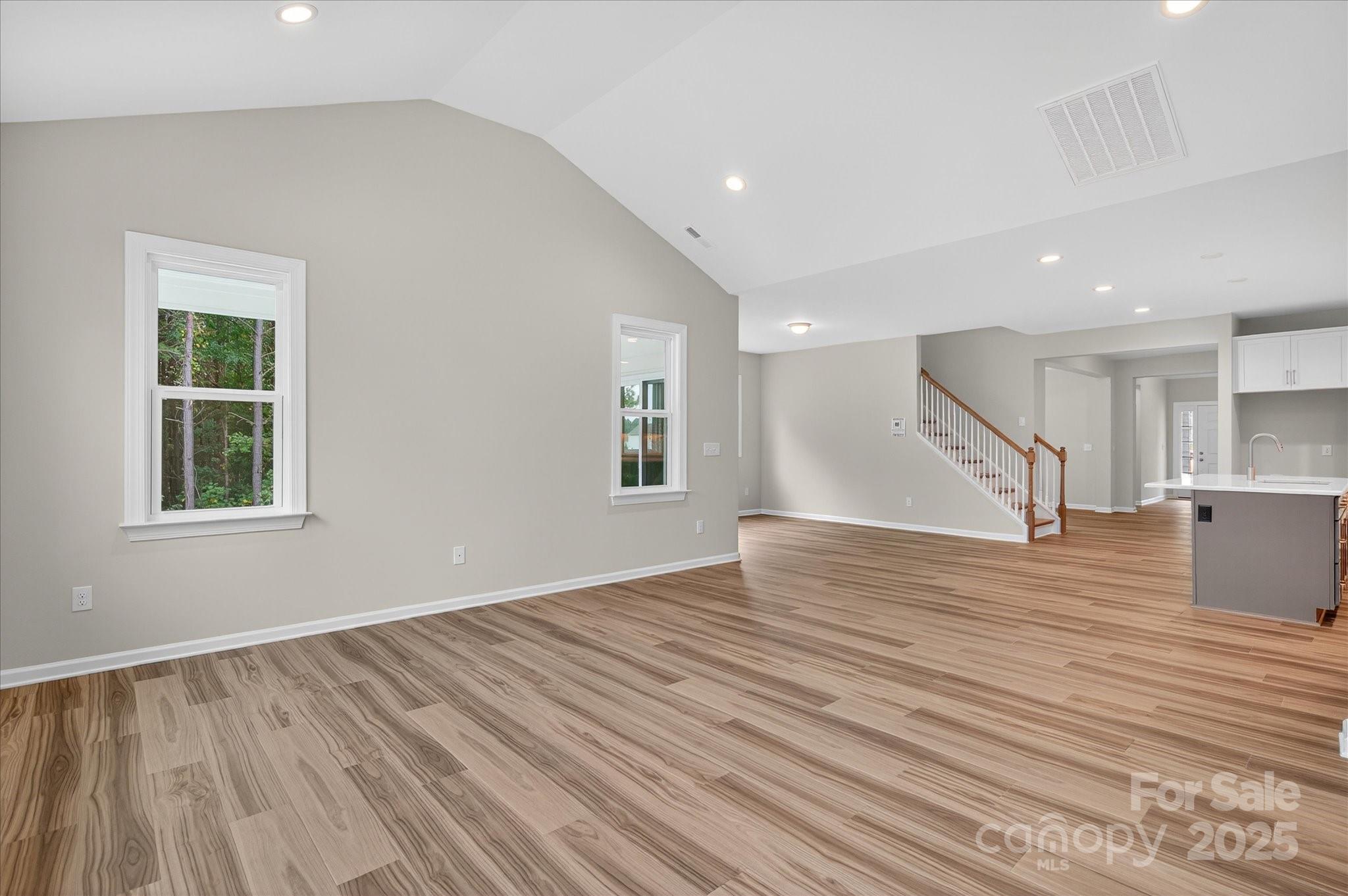 7926 Rolling Wheels Road, Unit KEN0008 Charlotte, NC 28215 - Photo 18 of 47 a view of empty room with wooden floor and kitchen view