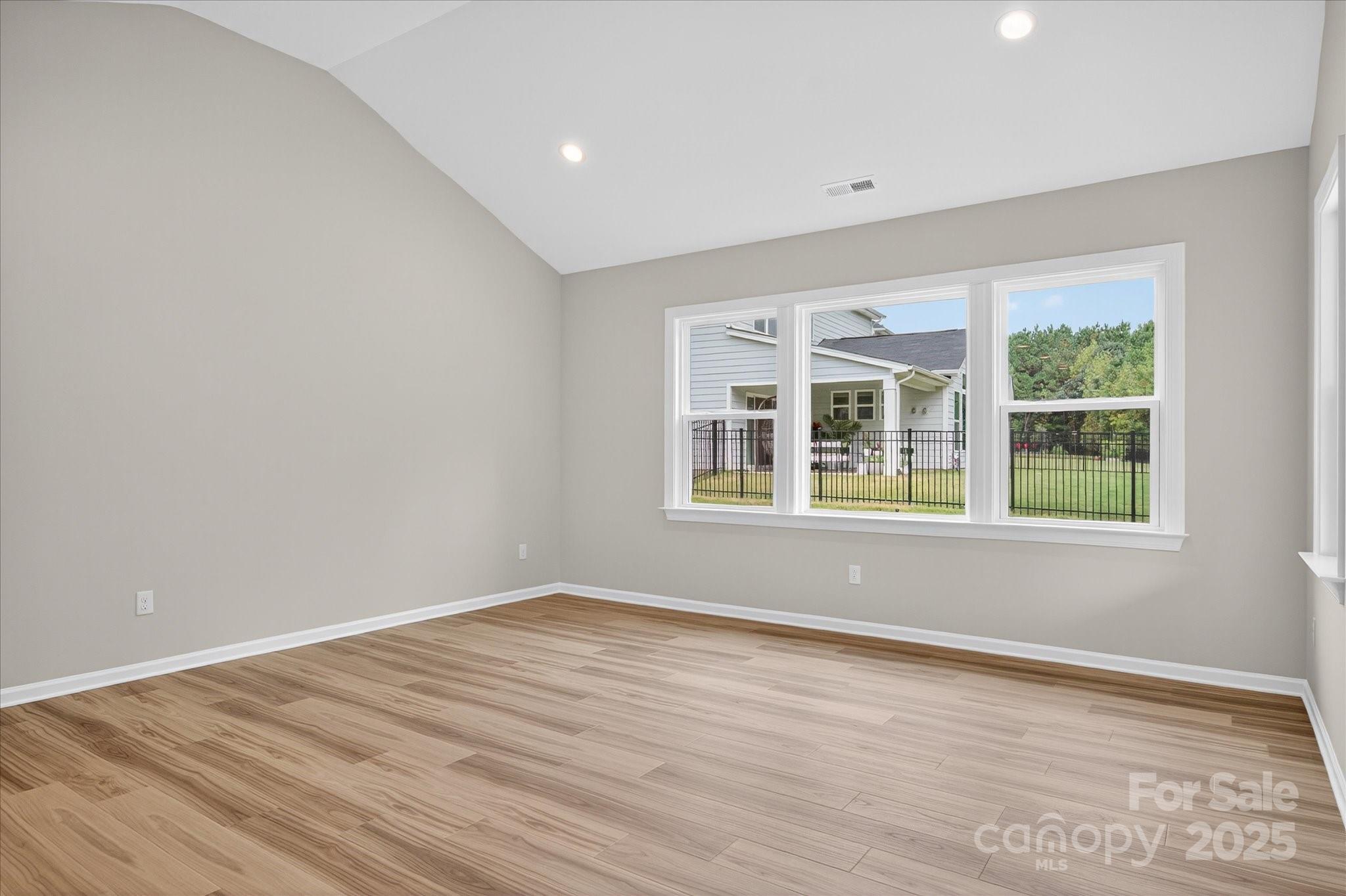 7926 Rolling Wheels Road, Unit KEN0008 Charlotte, NC 28215 - Photo 20 of 47 a view of an empty room with wooden floor and windows