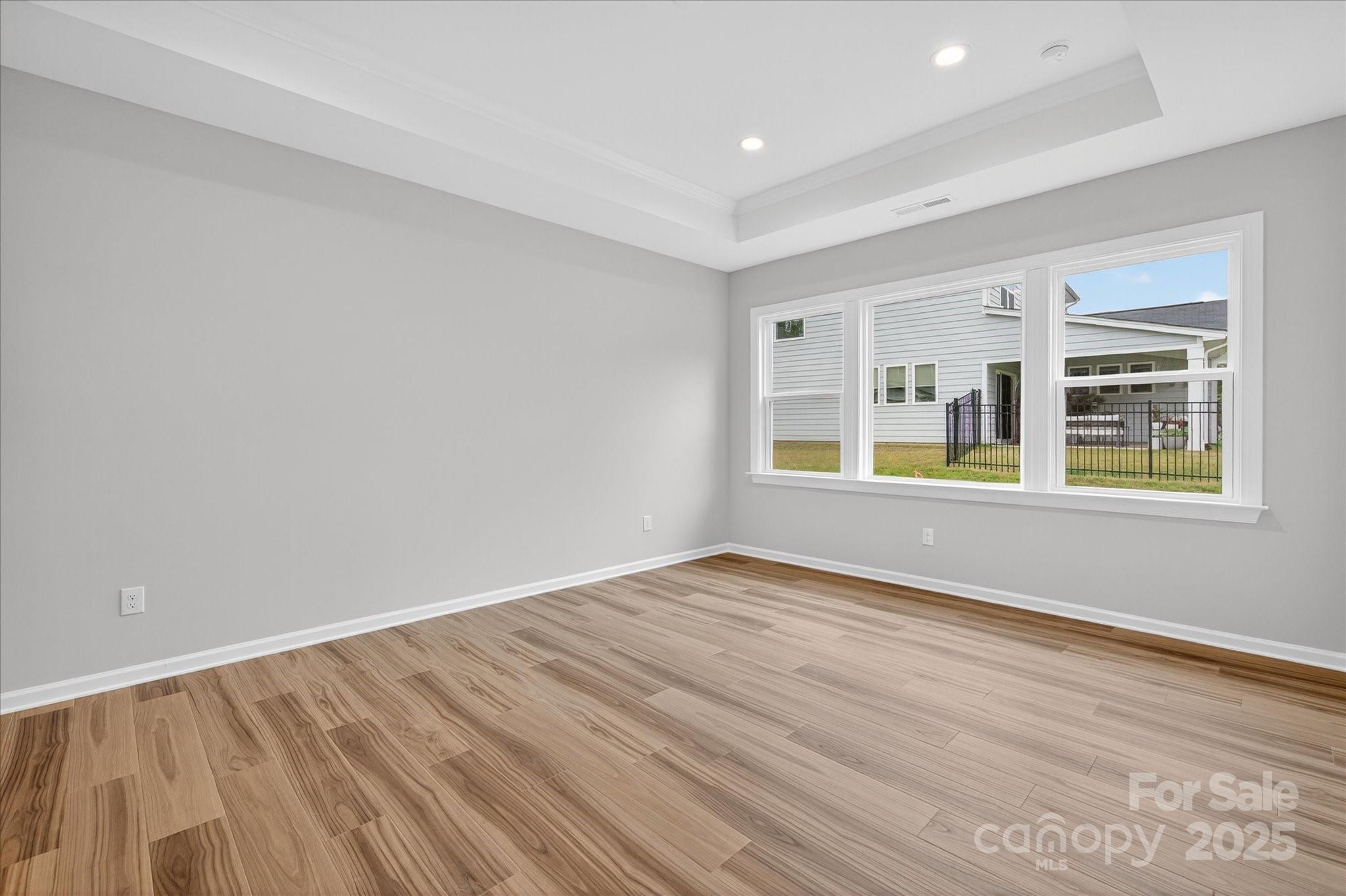 7926 Rolling Wheels Road, Unit KEN0008 Charlotte, NC 28215 - Photo 24 of 47 a view of empty room with wooden floor and fan