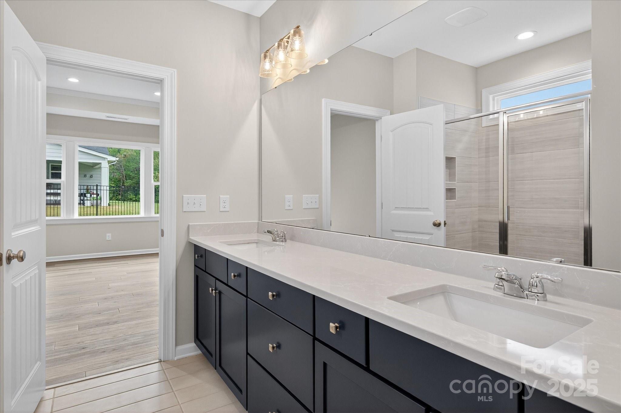7926 Rolling Wheels Road, Unit KEN0008 Charlotte, NC 28215 - Photo 27 of 47 a bathroom with a double vanity sink and a mirror