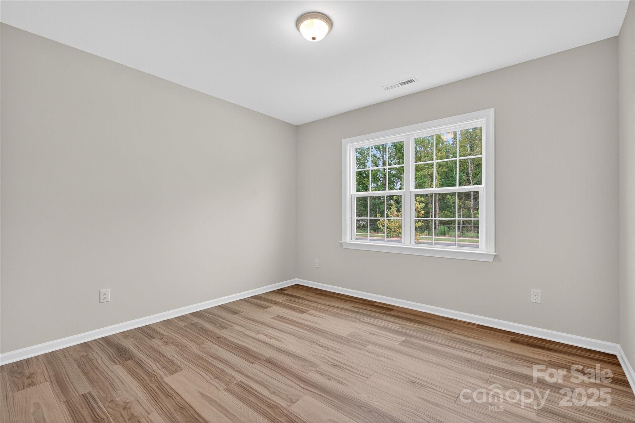 7926 Rolling Wheels Road, Unit KEN0008 Charlotte, NC 28215 - Photo 32 of 47 an empty room with wooden floor and windows