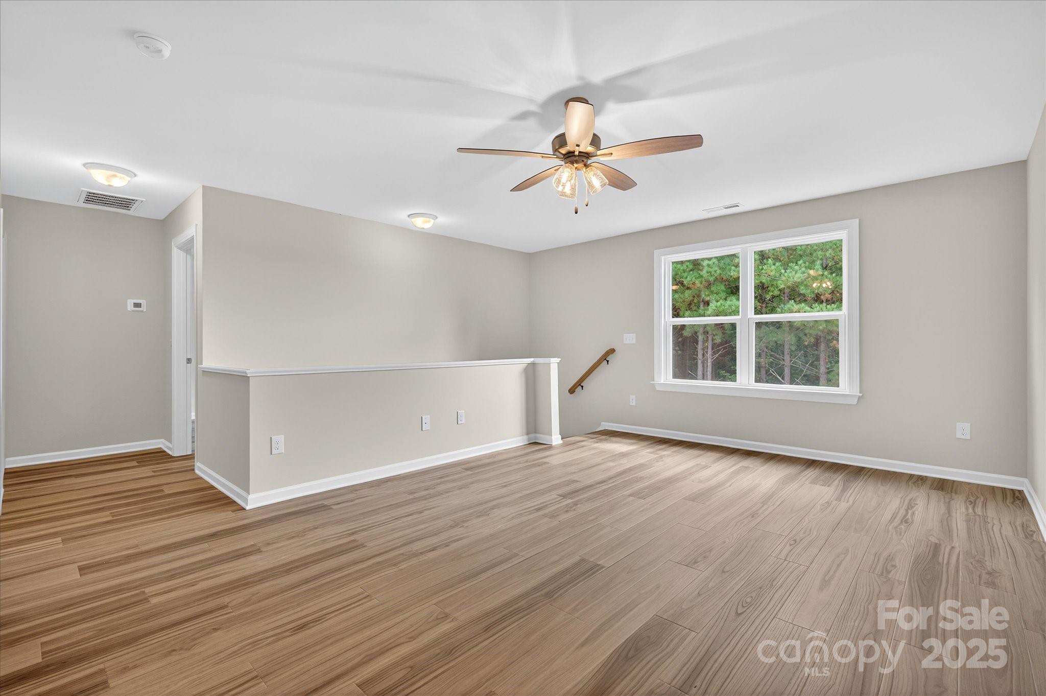 7926 Rolling Wheels Road, Unit KEN0008 Charlotte, NC 28215 - Photo 38 of 47 a view of an empty room with wooden floor and a window
