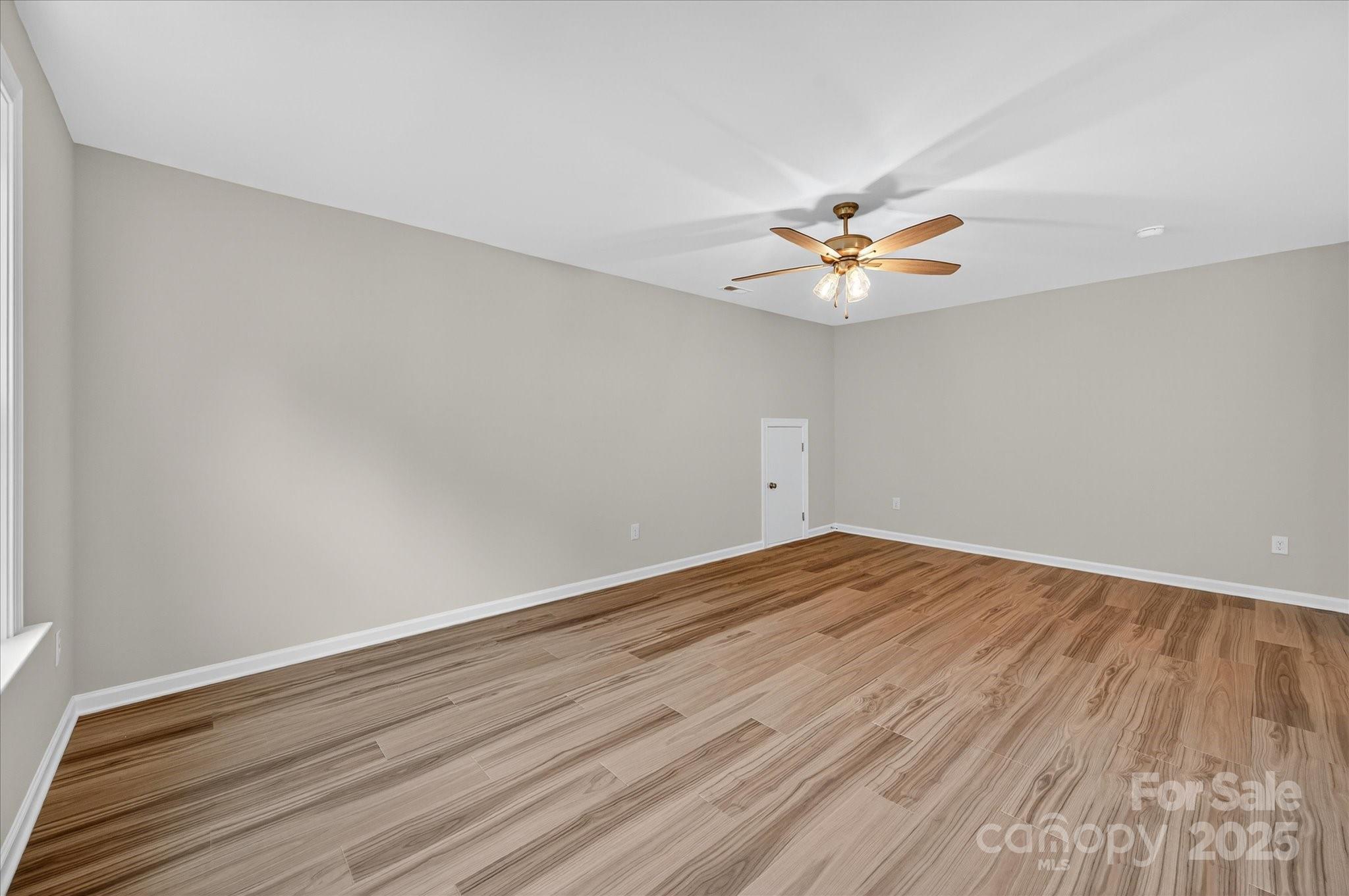 7926 Rolling Wheels Road, Unit KEN0008 Charlotte, NC 28215 - Photo 39 of 47 an empty room with wooden floor and a ceiling fan