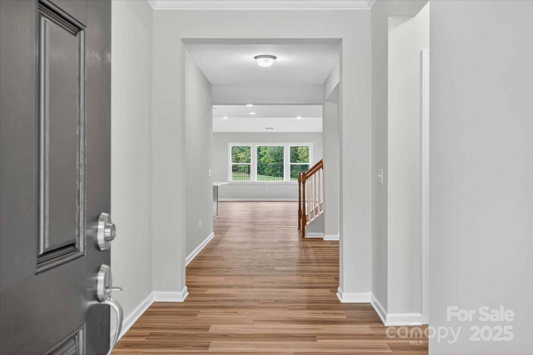 7926 Rolling Wheels Road, Unit KEN0008 Charlotte, NC 28215 - Photo 4 of 47 a view of a hallway with wooden floor and staircase