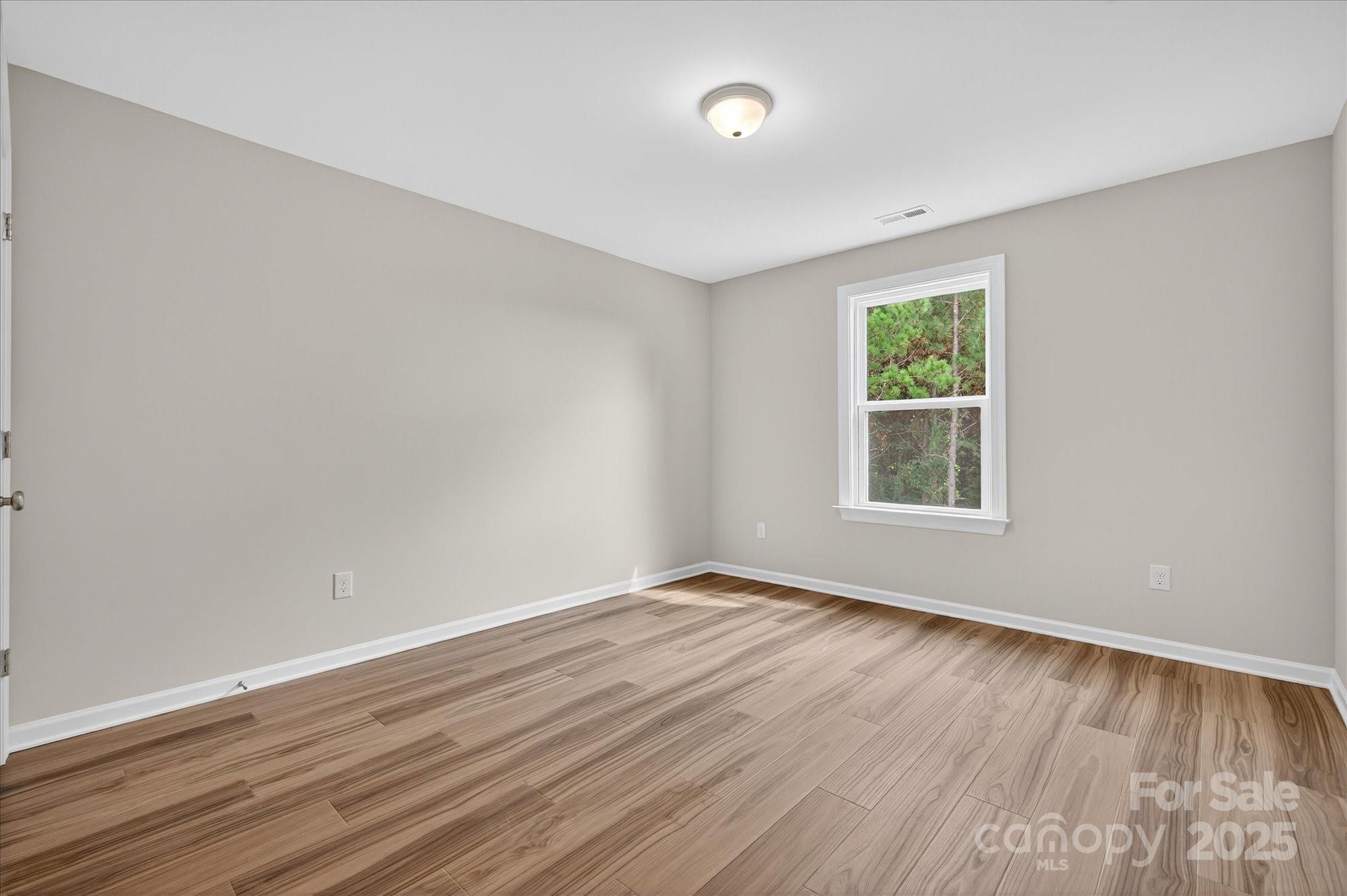 7926 Rolling Wheels Road, Unit KEN0008 Charlotte, NC 28215 - Photo 41 of 47 wooden floor in an empty room with a window
