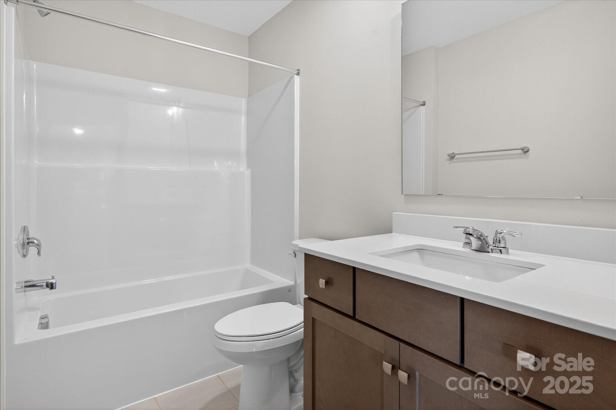 7926 Rolling Wheels Road, Unit KEN0008 Charlotte, NC 28215 - Photo 42 of 47 a bathroom with a granite countertop sink toilet a mirror and shower