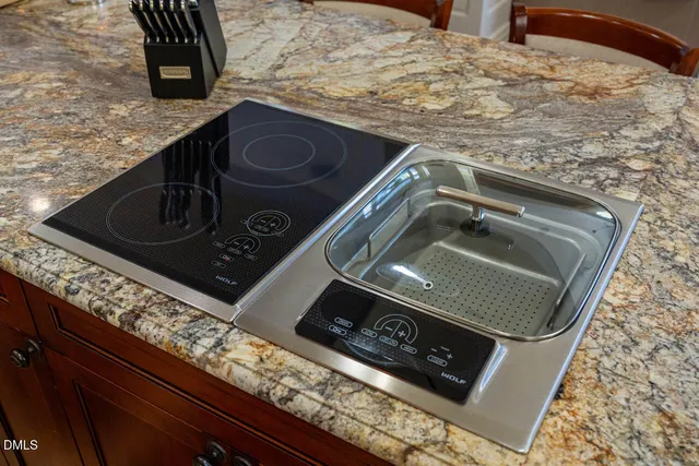 a kitchen with a stove a sink a refrigerator and white cabinets with wooden floor