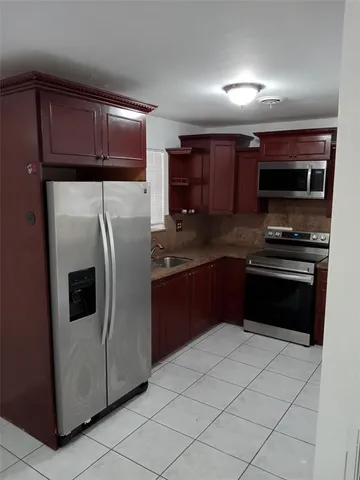 a kitchen with stainless steel appliances granite countertop a refrigerator and a stove top oven