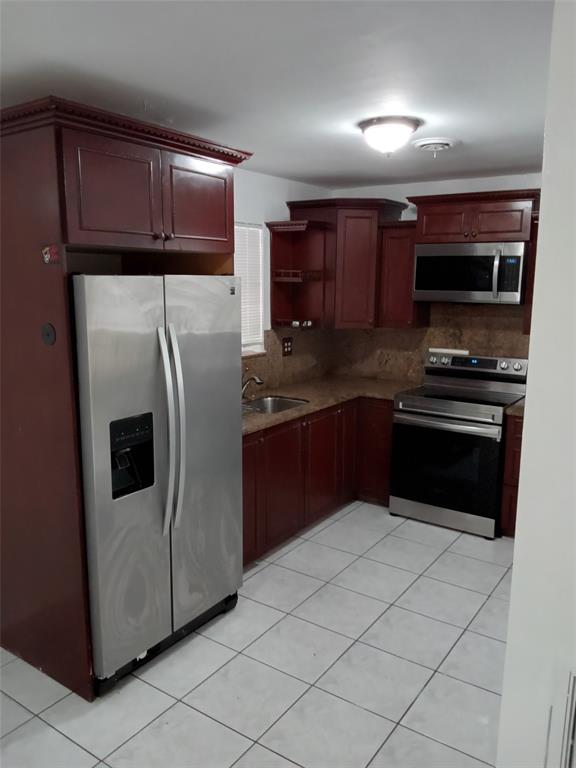 120 Northeast 26th Court Pompano Beach, FL 33064 - Photo 21 of 33 a kitchen with stainless steel appliances granite countertop a refrigerator and a stove top oven