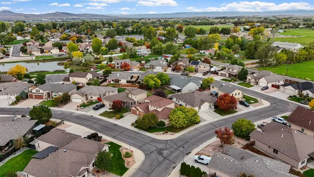 an aerial view of a city with lots of residential buildings ocean and mountain view in back