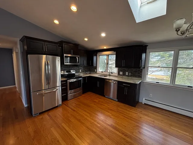a kitchen with granite countertop stainless steel appliances and wooden cabinets