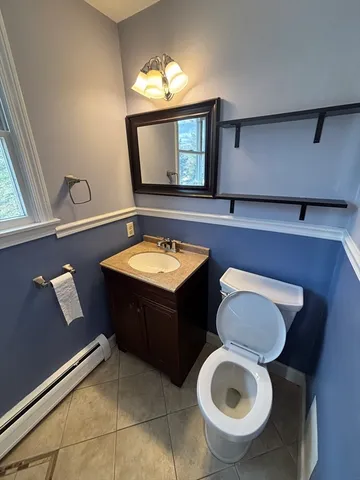 a bathroom with a toilet a sink and mirror