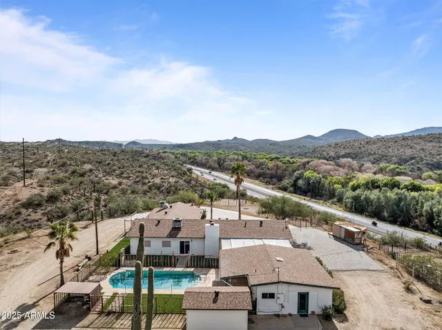 a view of a house with backyard sitting area and swimming pool