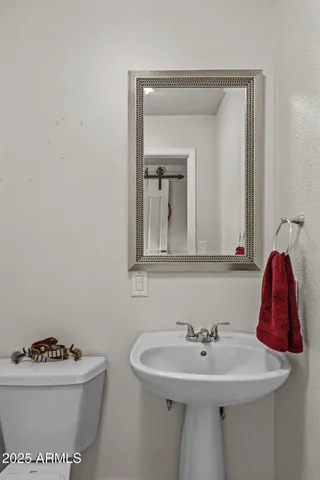 a living room with furniture a flat screen tv and a refrigerator