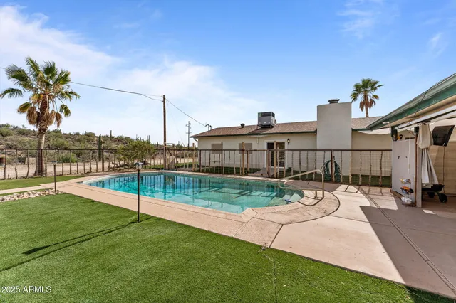 a view of a backyard with couches under an umbrella