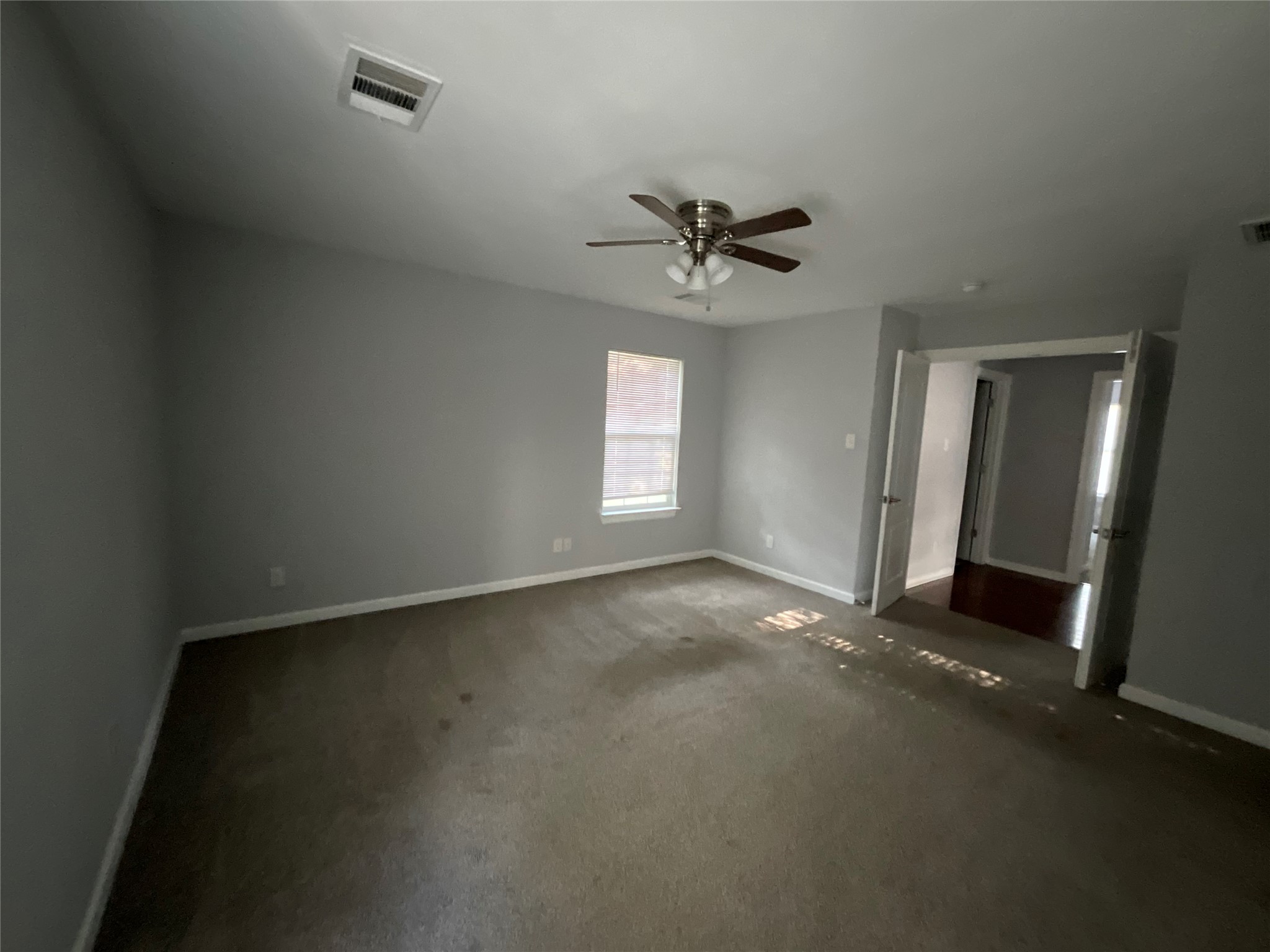 239 Old Firetower Road Bastrop, TX 78602 - Photo 36 of 39 master bedroom featuring double doors entry, dark colored carpet and a ceiling fan