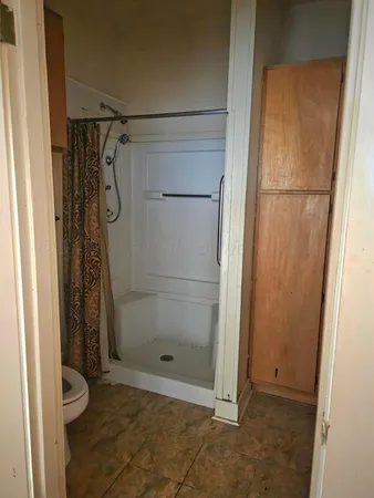 en empty room with windows and a ceiling fan