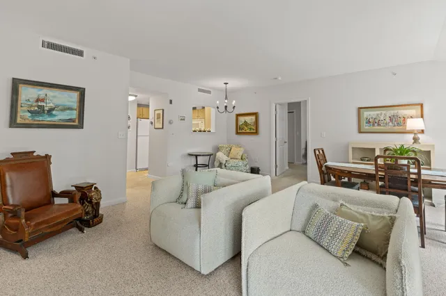 a living room with furniture and a view of kitchen