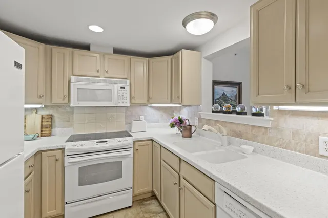 a kitchen with cabinets appliances a sink and a counter top space