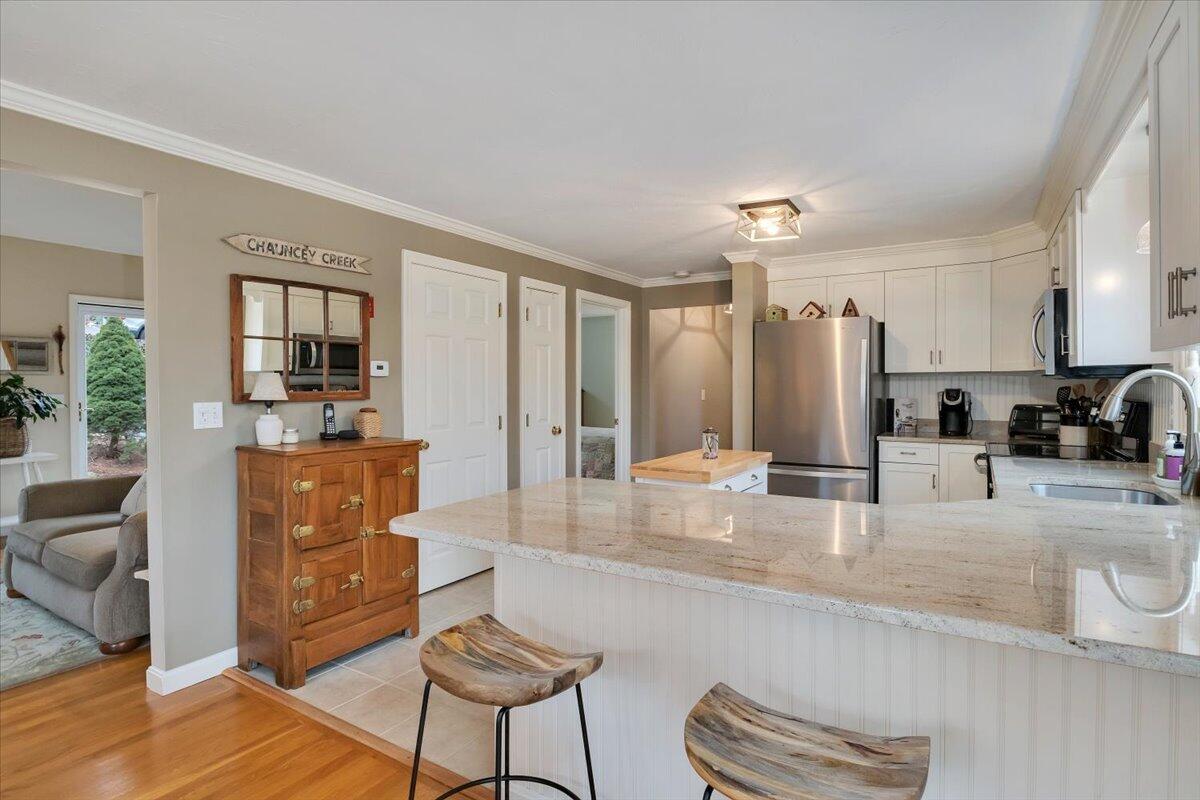 25 Christopher Hollow Road Sandwich, MA 02563 - Photo 13 of 47 a large living room with stainless steel appliances granite countertop a couch a dining table and chairs