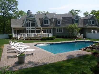 a front view of a house with swimming pool and a yard