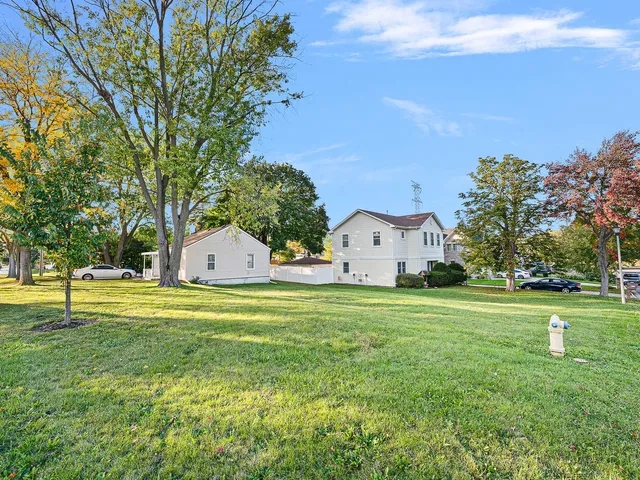 a front view of a house with a yard and trees