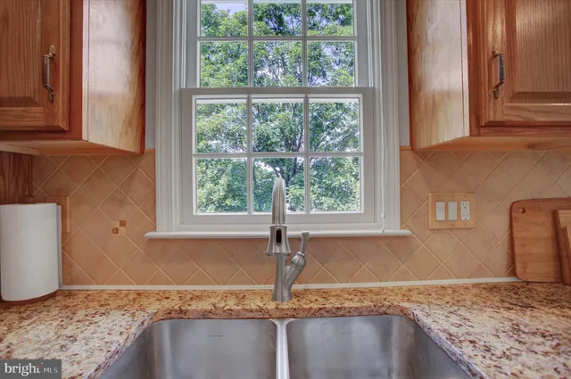 a metallic refrigerator freezer sitting in a kitchen