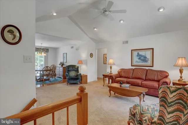 a living room with furniture a clock and a window