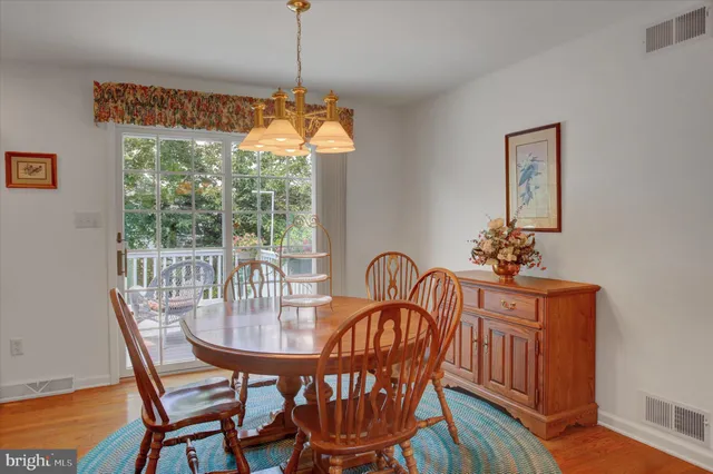 a dining room with furniture a chandelier and wooden floor