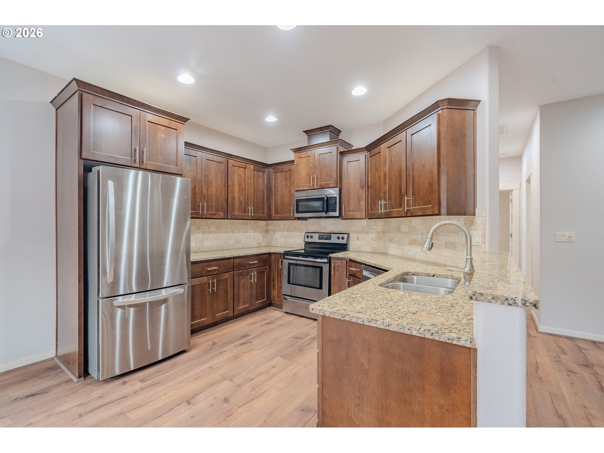 2156 Southwest 14th Drive Gresham, OR 97080 - Photo 7 of 48 a kitchen with granite countertop stainless steel appliances a refrigerator a stove top oven and a sink