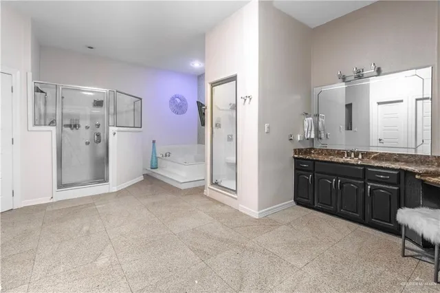 a large bathroom with a granite countertop double vanity sink a mirror and a shower