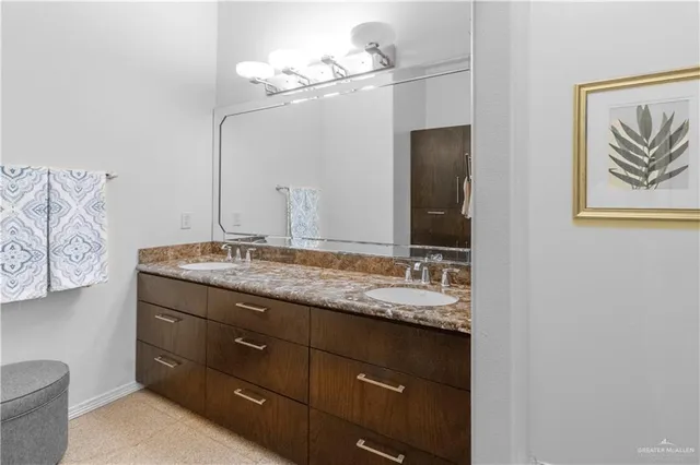 a bathroom with a granite countertop sink vanity and mirror