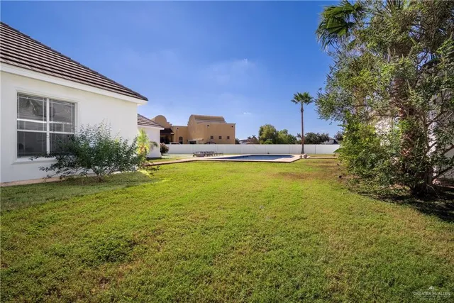 a view of a house with swimming pool and a yard