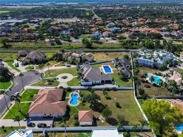 an aerial view of residential houses with outdoor space and swimming pool